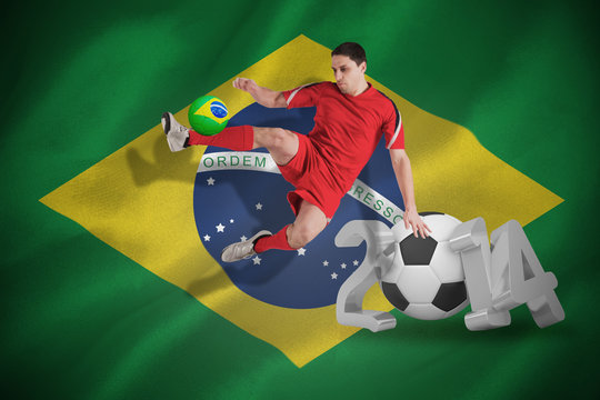 Fit football player jumping and kicking against world cup 2014 with brasil flag
