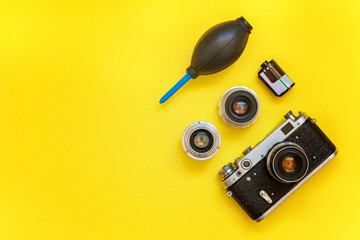 Canvas Print - Vintage film photo camera lens film roll and accessories on yellow colourful trendy modern fashion pin-up background. Technology development photographer hobby classic memory trip concept. Top View