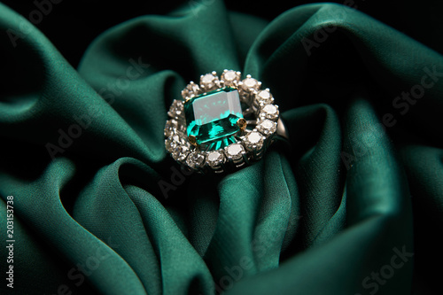 Fotografía Green emerald fashion engagement diamond ring on green satin background