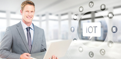 Poster - Happy businessman with laptop against windows overlooking city