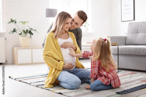 Fotomural Young pregnant woman with her family at home