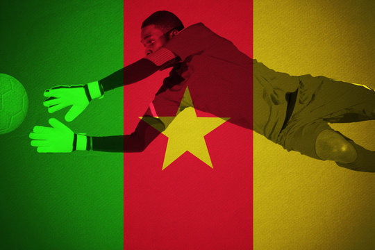 Goalkeeper in green making a save against cameroon national flag