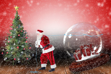 Wall Mural - Santa pulling snow globe of presents against shimmering light design over boards