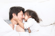 © paulaphoto - Father and daughter laughing and bonding in bed. Daddy and his little girl spending time at home. Fun love family lifestyle concept.