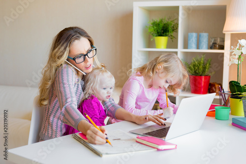 Cuadros en Lienzo Busy woman trying to work while babysitting two kids