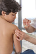 © JPC-PROD - little boy looking at his arm, while receiving vaccine immunization