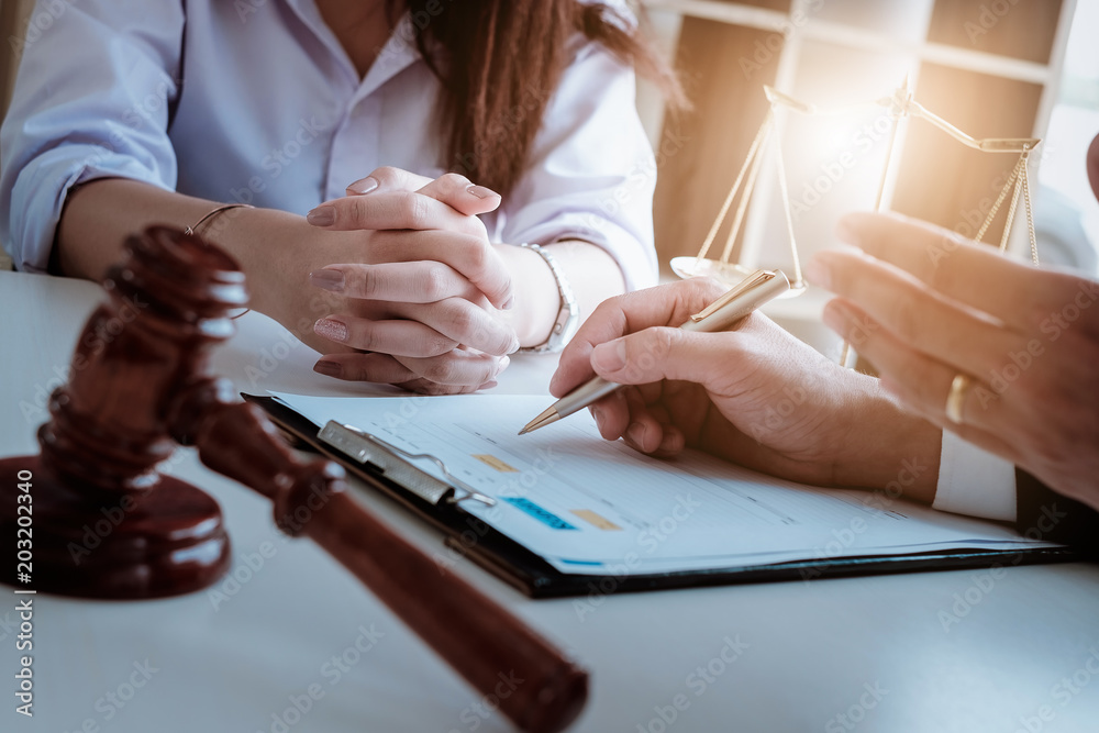 Business woman and lawyers discussing contract papers with brass scale on wooden desk in office. Law, legal services, advice, Justice and real estate concept. - obrazy, fototapety, plakaty 