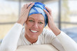 © JPC-PROD - Elegant oncology patient with headscarf sitting on couch, smiling
