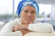 © JPC-PROD - beautiful oncology patient with headscarf sitting on couch, smiling