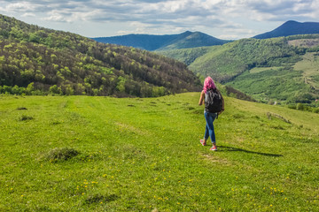 soft focus backpack travel girl with pink hair back to camera on beautiful nature forest mountain landscape