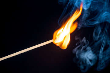 Burning match isolated on black background