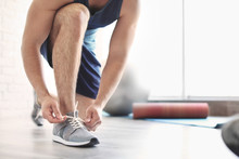 Man Putting On Training Shoes Indoors, Closeup