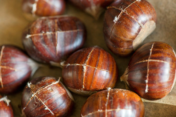 Wall Mural - Chestnuts being prepared for baking with a knife-cut cross on top of each nut 