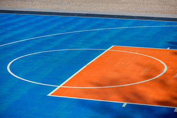 Abstract, blue background of newly made outdoor basketball court in park. Visible asphalt texture, freshly painted lines