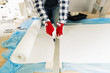 © artursfoto - Handyman, worker measuring wallpaper to cut. Home renovation and repair concept