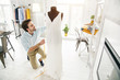 © zinkevych - Unbelievable dress. Joyful male dressmaker smiling and making a new dressale dressmaker smiling and making a new dress