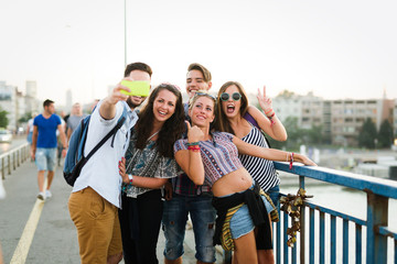 Happy young friends taking selfie on street