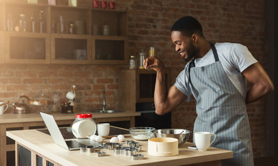 African-american man baking cookies at home kitchen