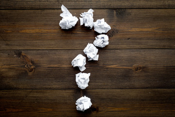 Poster - Question mark lined with crumpled paper on dark wooden background top view copy space