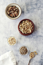 High Angle View Of Various Nuts In Bowls On Table