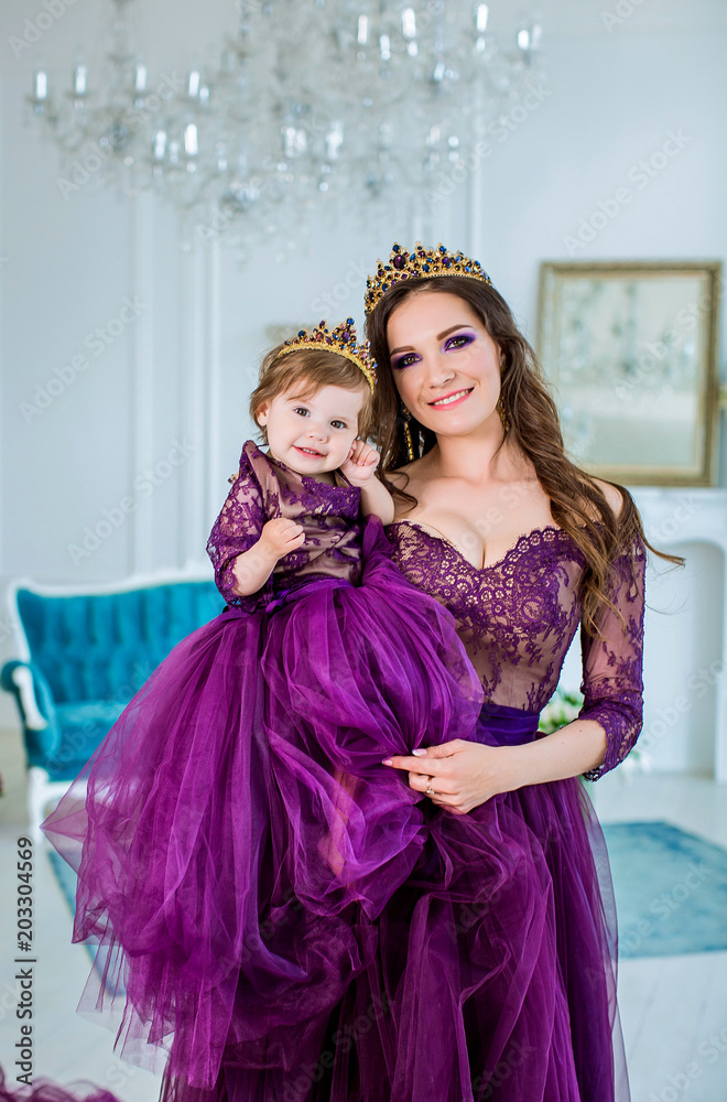 Beautiful princess girl in purple dress holding small daughter in her arms  Stock Photo | Adobe Stock