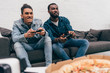 © LIGHTFIELD STUDIOS - multicultural young male friends with joysticks playing video game