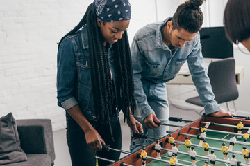 Wall Mural - cropped shot of young multiethnic group of friends playing table football