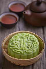 Chinese mid autumn festival foods. Snow skin mooncake on wooden table with text Green 