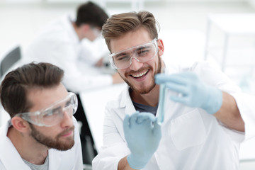 Wall Mural - two biologist examining liquid in a test tube