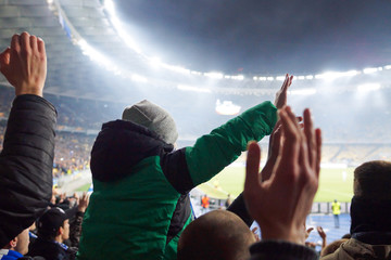 Youn white boy watchin football game at stadium