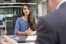 Focused Indian Female Customer Meeting With Financial Advisor. Young Beautiful Candidate At Job Interview In Modern Office Space. Business Consulting Or Employment Concept