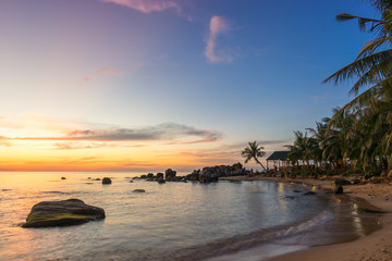 Wall Mural - Scenic colorful sunset on Phu Quoc Island Long Beach in Vietnam. Seascape on sandy coast with palm trees and stones in water