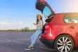 © Oleksandr Kozak - Young woman traveler sitting on hatchback car with outdoor sunny  background