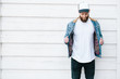 © 4Max - Hipster handsome male model with beard wearing white blank t-shirt and a baseball cap with space for your logo or design in casual urban style