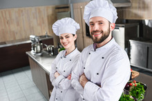 Professional Team Of Male And Female Cooks Standing With Folded Arms On Kitchen