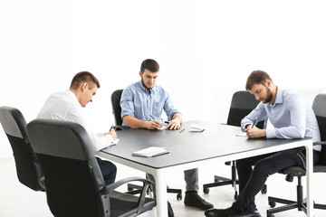 Poster - Young men sitting together at table, indoors. Unity concept