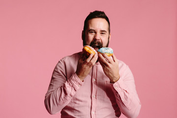 Man trying to eat two donuts