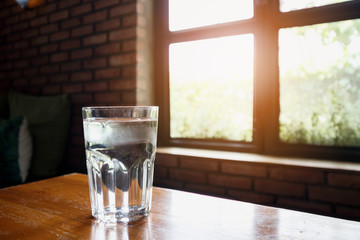 Wall Mural - glass of mineral water on wood table in restaurant