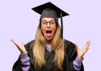 Canvas Print - Young woman university graduate student happy and surprised cheering expressing wow gesture