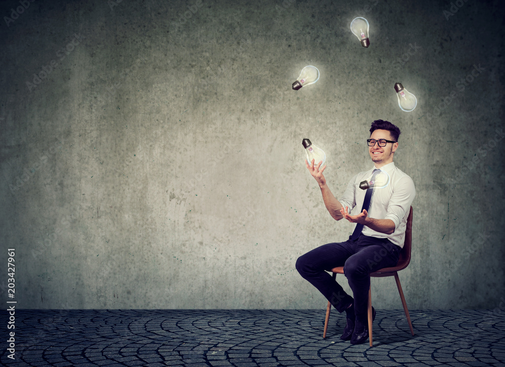 Man juggling with glowing light bulbs - obrazy, fototapety, plakaty 