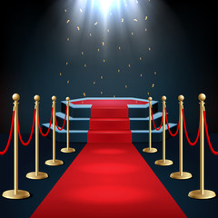 Podium with red carpet and barrier rope in glow of spotlights