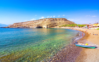 Matala beach with caves on the rocks that were used as a roman cemetery and at the decade of 70's were living hippies from all over the world, Crete, Greece