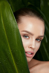 Wall Mural - Beauty Woman Face With Healthy Skin And Green Plant