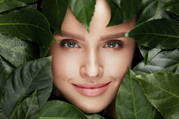 Wall Mural - Natural Beauty. Beautiful Woman Face In Green Leaves.