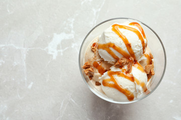 Wall Mural - bowl with caramel ice cream on light background, top view