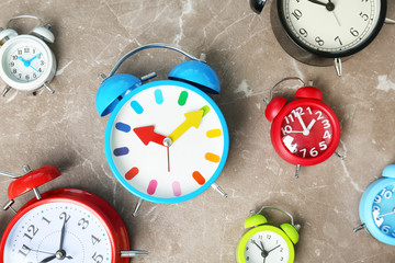 Poster - Many different alarm clocks on table. Time change concept