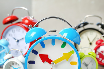 Poster - Blue alarm clock and many others on background. Time change concept