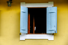 White And Blue Window On Yellow Wall