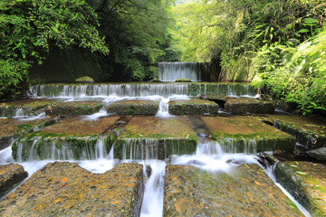 Summer scenery of beautiful waterfalls cascading down a stream in a shady jungle in Taiwan ~ Cool refreshing cascades hidden in a mysterious forest of lush greenery