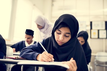 diverse muslim children studying in classroom